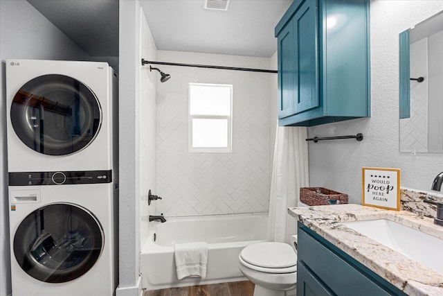 5986 Field Ct, Granbury, TX 76048 - full bath featuring stacked washing machine and dryer, wood finished floors, shower / bath combo with shower curtain, and vanity