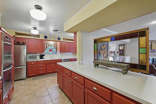 1615 Lopo Rd, Flower Mound, TX 75028 - kitchen featuring stainless steel appliances, light countertops, dark brown cabinets, light tile patterned floors, and backsplash