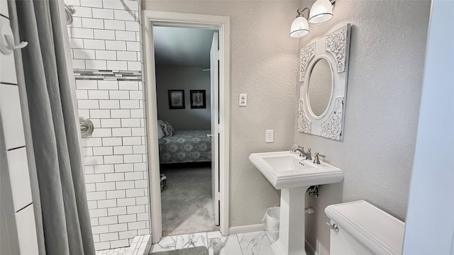 1615 Lopo Rd, Flower Mound, TX 75028 - ensuite bathroom featuring marble look tiles, curtained shower, and a textured wall