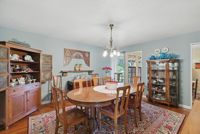 1615 Lopo Rd, Flower Mound, TX 75028 - dining area with a chandelier, light wood-style floors, and a textured ceiling