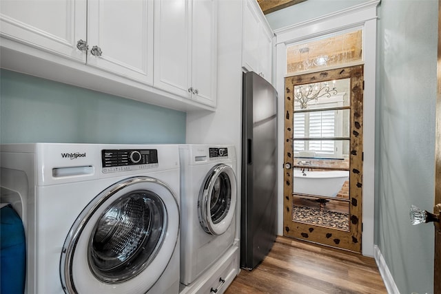 8029 N River Xing, China Spring, TX 76633 - laundry area with independent washer and dryer, cabinet space, and wood finished floors