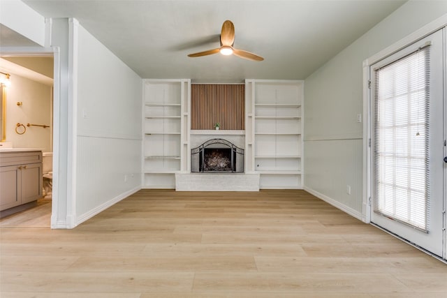 2018 Vail Dr, Garland, TX 75044 - unfurnished living room with ceiling fan, a fireplace, light wood-style floors, and built in shelves