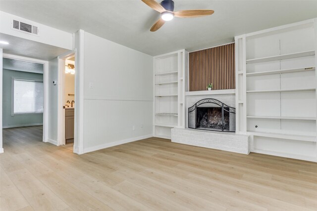 2018 Vail Dr, Garland, TX 75044 - unfurnished living room with a ceiling fan, a brick fireplace, wood finished floors, built in shelves, and wainscoting