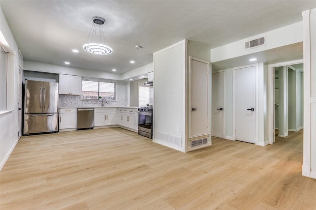 2018 Vail Dr, Garland, TX 75044 - kitchen featuring appliances with stainless steel finishes, light wood-type flooring, white cabinetry, light countertops, and decorative light fixtures