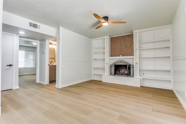 2018 Vail Dr, Garland, TX 75044 - unfurnished living room featuring ceiling fan, light wood-style floors, a fireplace, and built in features