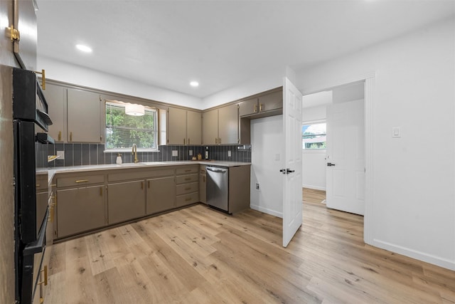 1813 Madera Dr, Waco, TX 76705 - kitchen featuring stainless steel dishwasher, light wood finished floors, light countertops, backsplash, and plenty of natural light