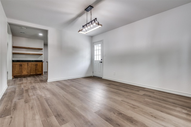 2775 E Overton Rd, Dallas, TX 75216 - unfurnished dining area with light wood-style floors and baseboards