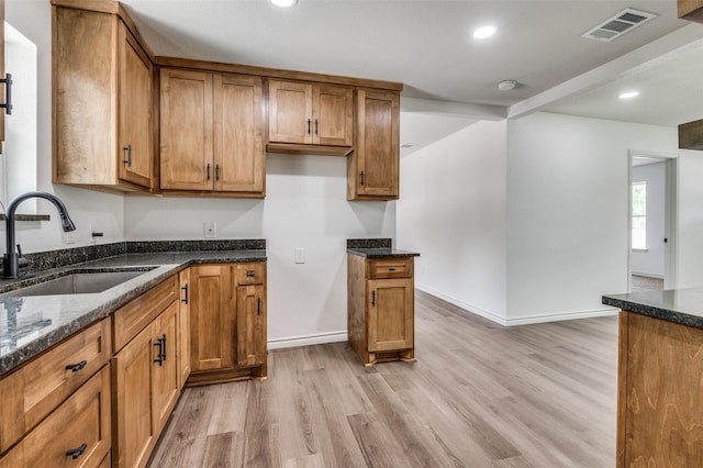 2775 E Overton Rd, Dallas, TX 75216 - kitchen with light wood-type flooring, dark stone countertops, brown cabinetry, and recessed lighting