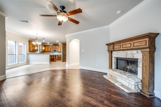 1909 Rocky Ct, Corinth, TX 76208 - unfurnished living room with ceiling fan, crown molding, arched walkways, a chandelier, and a fireplace