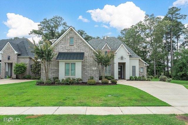 140 St Andrews Ln, Benton, LA 71006 - french country inspired facade featuring a front lawn, brick siding, and a standing seam roof