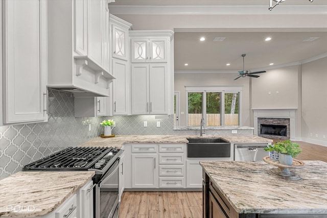 140 St Andrews Ln, Benton, LA 71006 - kitchen featuring appliances with stainless steel finishes, ornamental molding, ceiling fan, white cabinets, and light wood-style flooring