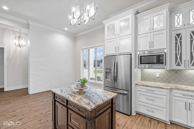 140 St Andrews Ln, Benton, LA 71006 - kitchen with stainless steel appliances, a chandelier, ornamental molding, light wood finished floors, and recessed lighting