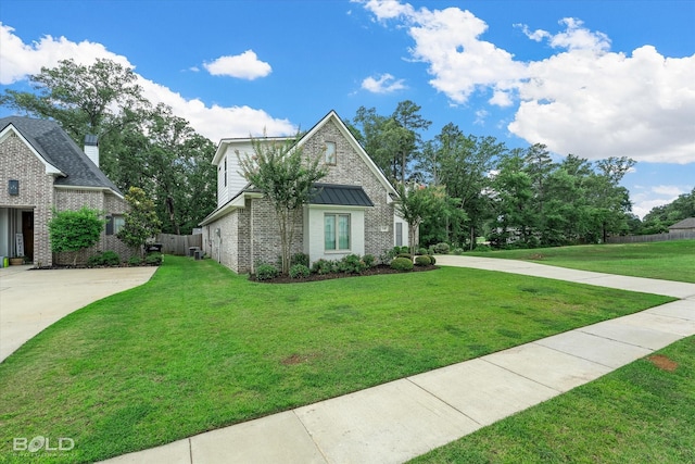 140 St Andrews Ln, Benton, LA 71006 - view of front of property with brick siding, concrete driveway, a standing seam roof, and a metal roof