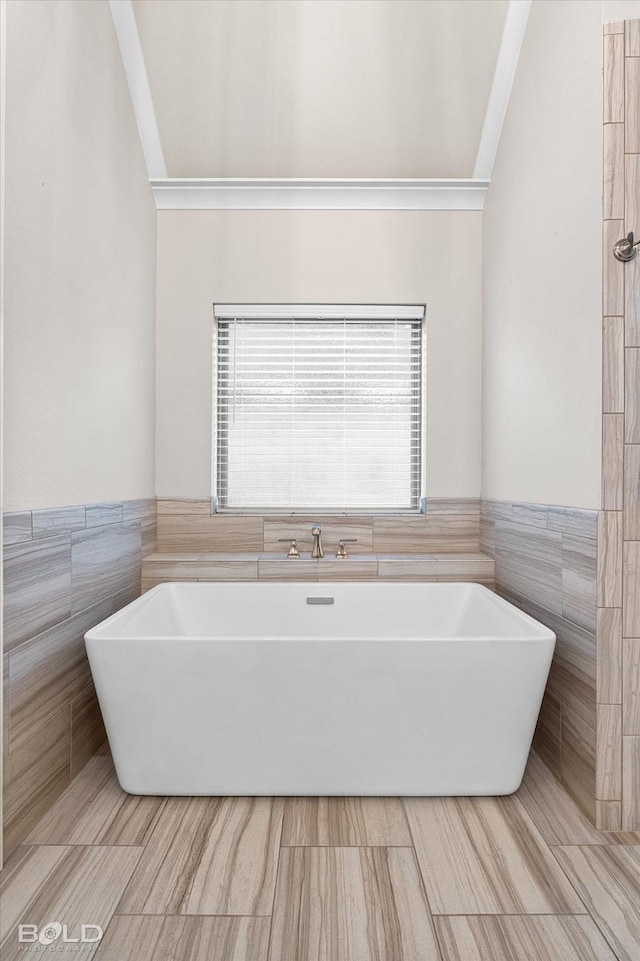 140 St Andrews Ln, Benton, LA 71006 - full bath with tile walls, a soaking tub, ornamental molding, and a wainscoted wall
