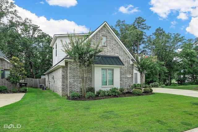 140 St Andrews Ln, Benton, LA 71006 - view of side of home with brick siding, a standing seam roof, driveway, and a metal roof
