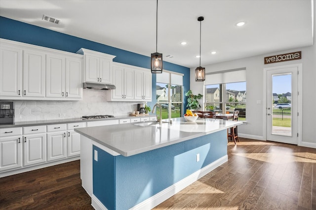3005 Landmark Pl, Heath, TX 75126 - kitchen with dark wood-type flooring, under cabinet range hood, healthy amount of natural light, tasteful backsplash, and recessed lighting