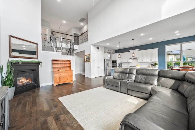 3005 Landmark Pl, Heath, TX 75126 - living room featuring dark wood-style flooring, a glass covered fireplace, a towering ceiling, and recessed lighting