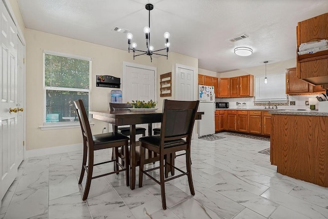 1011 Reed Rd, Denton, TX 76205 - dining area with light marble finish flooring and a chandelier