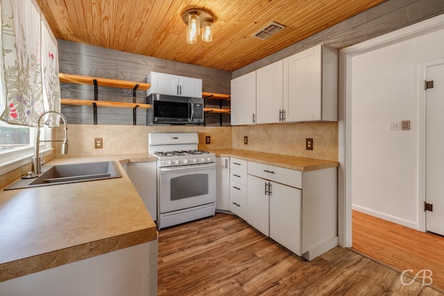 733 N Willis St, Abilene, TX 79603 - kitchen with gas range gas stove, open shelves, stainless steel microwave, wooden ceiling, and backsplash