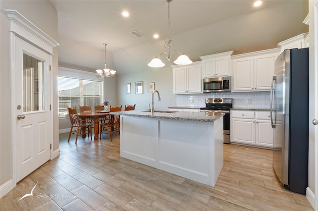 7362 Connor Rd, Abilene, TX 79602 - kitchen featuring stainless steel appliances, a chandelier, lofted ceiling, decorative backsplash, and white cabinets