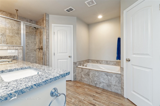 7362 Connor Rd, Abilene, TX 79602 - full bathroom with a stall shower, a bath, wood finished floors, and vanity