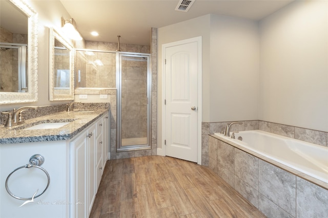 7362 Connor Rd, Abilene, TX 79602 - full bathroom featuring a shower stall, double vanity, a garden tub, and wood finished floors