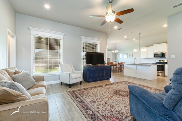 7362 Connor Rd, Abilene, TX 79602 - living room with ceiling fan, recessed lighting, light wood-style flooring, and a chandelier