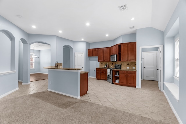 10305 Matador Dr, Mckinney, TX 75072 - kitchen featuring stainless steel appliances, light tile patterned floors, arched walkways, decorative backsplash, and light stone counters