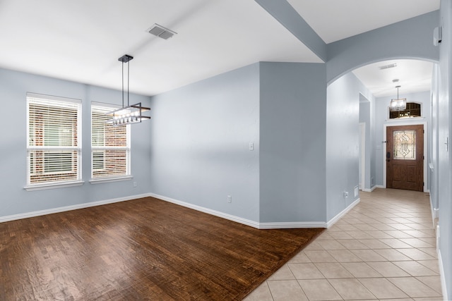 10305 Matador Dr, Mckinney, TX 75072 - entrance foyer with arched walkways, healthy amount of natural light, a chandelier, and light tile patterned floors
