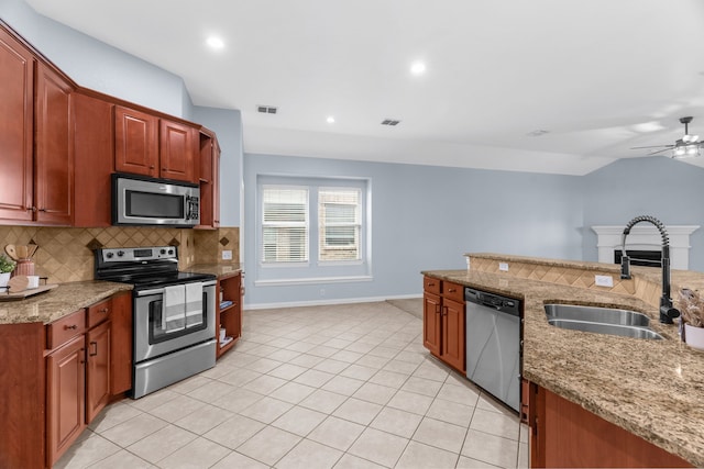 10305 Matador Dr, Mckinney, TX 75072 - kitchen with stainless steel appliances, tasteful backsplash, a ceiling fan, light stone counters, and light tile patterned floors