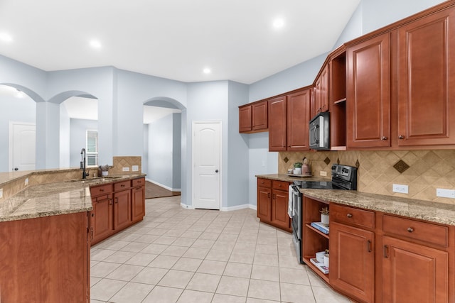 10305 Matador Dr, Mckinney, TX 75072 - kitchen with electric range, black microwave, arched walkways, decorative backsplash, and light stone counters