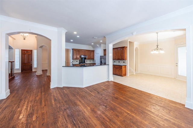 220 Justin Rd, Murphy, TX 75094 - unfurnished living room with arched walkways, ornamental molding, a chandelier, dark wood finished floors, and recessed lighting