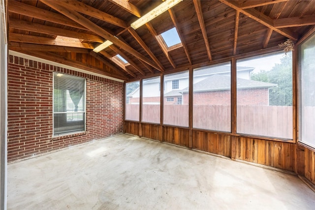220 Justin Rd, Murphy, TX 75094 - unfurnished sunroom featuring brick wall, concrete flooring, a skylight, vaulted ceiling, and wood walls