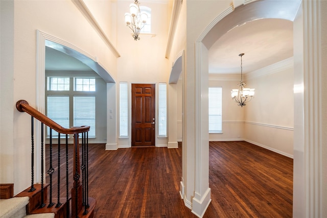 220 Justin Rd, Murphy, TX 75094 - foyer entrance featuring a chandelier, arched walkways, dark wood-style flooring, stairs, and crown molding
