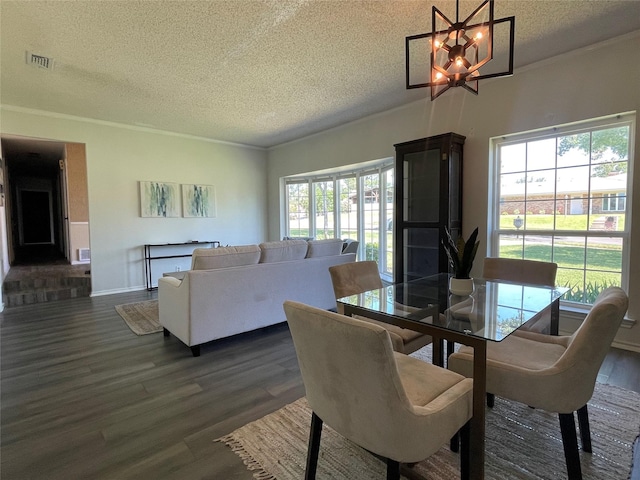1610 Newsom Ct, Pantego, TX 76013 - dining area with a textured ceiling, dark wood-style flooring, a chandelier, and crown molding