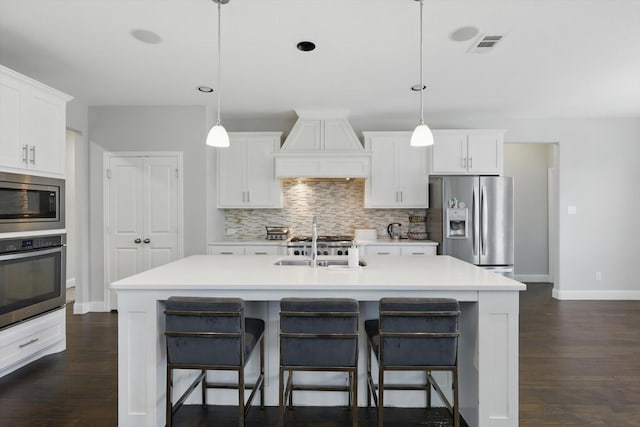1617 Commons Way, Prosper, TX 75078 - kitchen featuring stainless steel appliances, custom range hood, decorative backsplash, dark wood-style flooring, and white cabinetry