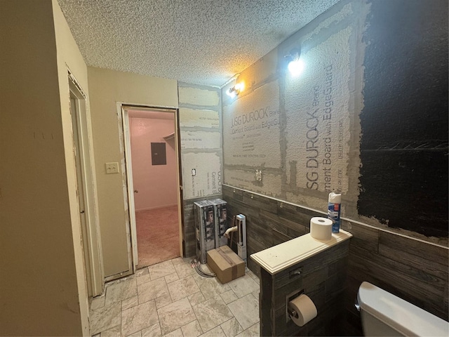 1909 Cloisters Dr Unit 1025, Arlington, TX 76011 - bathroom featuring a textured ceiling, electric panel, and stone finish flooring