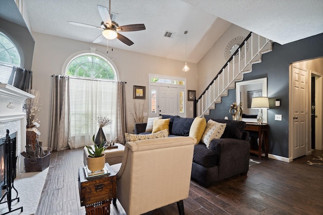 4443 Mercer St, Grand Prairie, TX 75052 - living area featuring stairway, wood-type flooring, a ceiling fan, a textured ceiling, and a warm lit fireplace