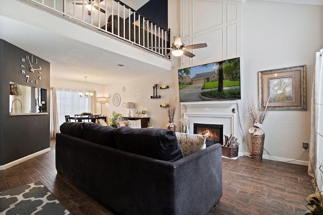 4443 Mercer St, Grand Prairie, TX 75052 - living area with a chandelier, a warm lit fireplace, dark wood-type flooring, ceiling fan, and a high ceiling