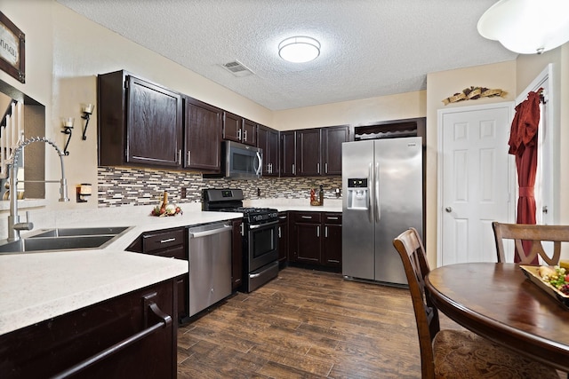 4443 Mercer St, Grand Prairie, TX 75052 - kitchen with stainless steel appliances, light countertops, dark brown cabinets, dark wood-style flooring, and a textured ceiling