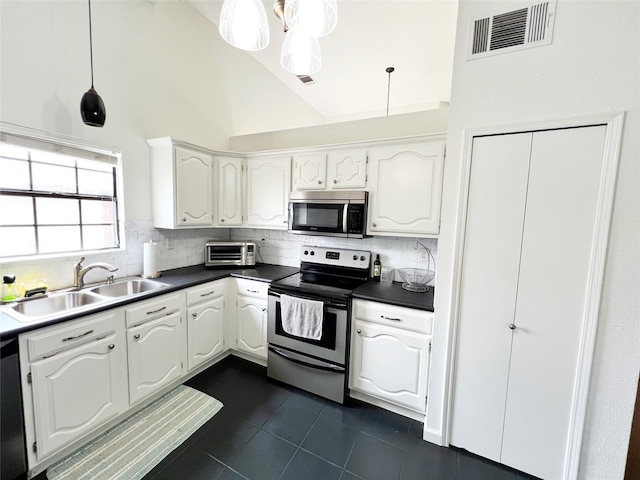 6828 Younger Dr, The Colony, TX 75056 - kitchen with appliances with stainless steel finishes, dark tile patterned flooring, dark countertops, tasteful backsplash, and high vaulted ceiling