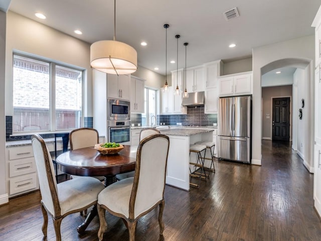 4141 Maclin Dr, Celina, TX 75009 - dining space featuring arched walkways, dark wood finished floors, and recessed lighting