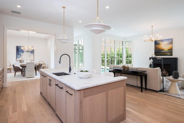 3725 Stratford Ave, Highland Park, TX 75205 - kitchen featuring a chandelier, light wood-style floors, light brown cabinetry, recessed lighting, and an island with sink
