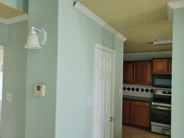 2001 Mark Twain Ln, Denton, TX 76210 - kitchen featuring stainless steel stove, black microwave, crown molding, decorative backsplash, and dark countertops