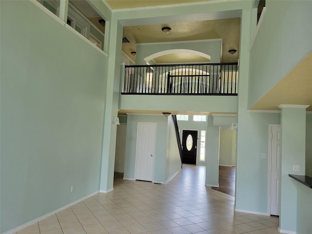 2001 Mark Twain Ln, Denton, TX 76210 - unfurnished living room featuring a high ceiling, light tile patterned flooring, and crown molding