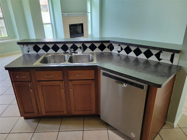 2001 Mark Twain Ln, Denton, TX 76210 - kitchen featuring stainless steel dishwasher, dark countertops, plenty of natural light, and light tile patterned floors
