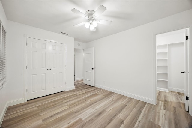2207 English Dr, Garland, TX 75041 - unfurnished bedroom featuring a closet, light wood-style floors, a ceiling fan, and a spacious closet