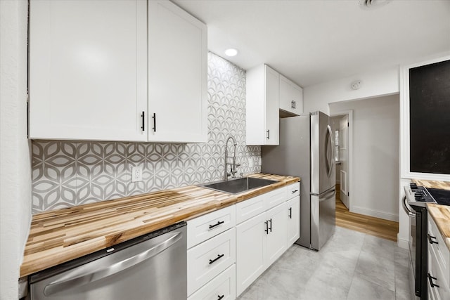2207 English Dr, Garland, TX 75041 - kitchen with appliances with stainless steel finishes, butcher block countertops, and white cabinetry