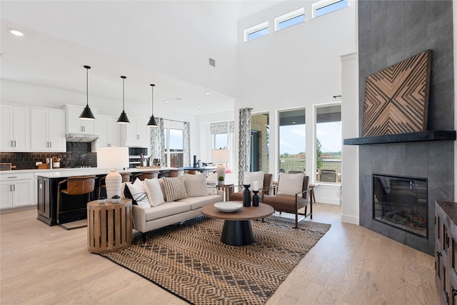 2420 Bernham Dr, Celina, TX 75009 - living room with light wood-style flooring, a fireplace, recessed lighting, and a towering ceiling
