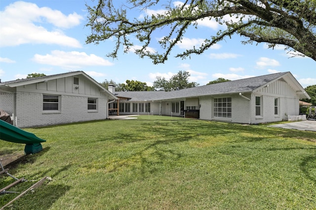 6805 Benito Ct, Fort Worth, TX 76126 - back of property with board and batten siding, brick siding, a lawn, and a patio